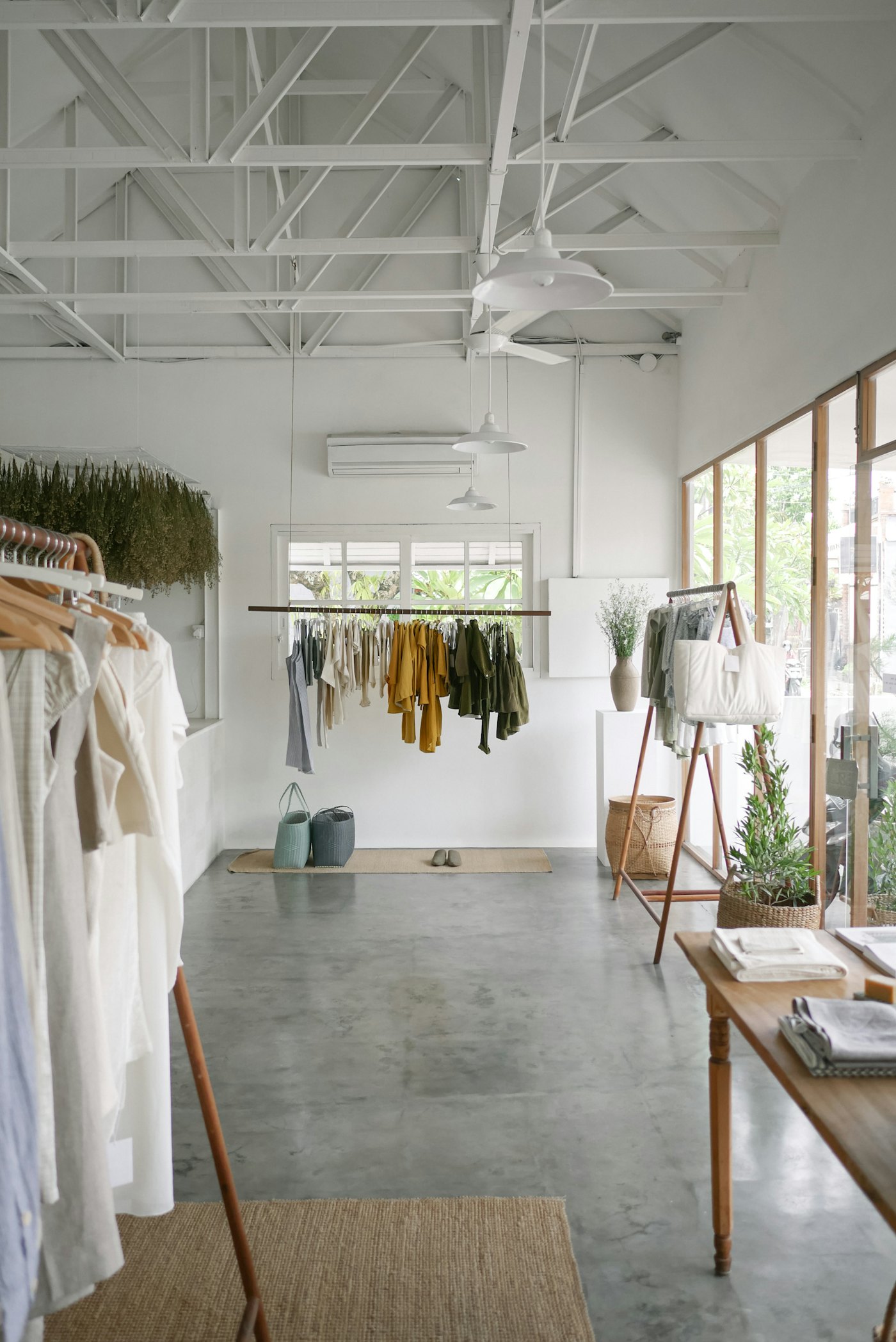A bright clothing store with garments on rails
